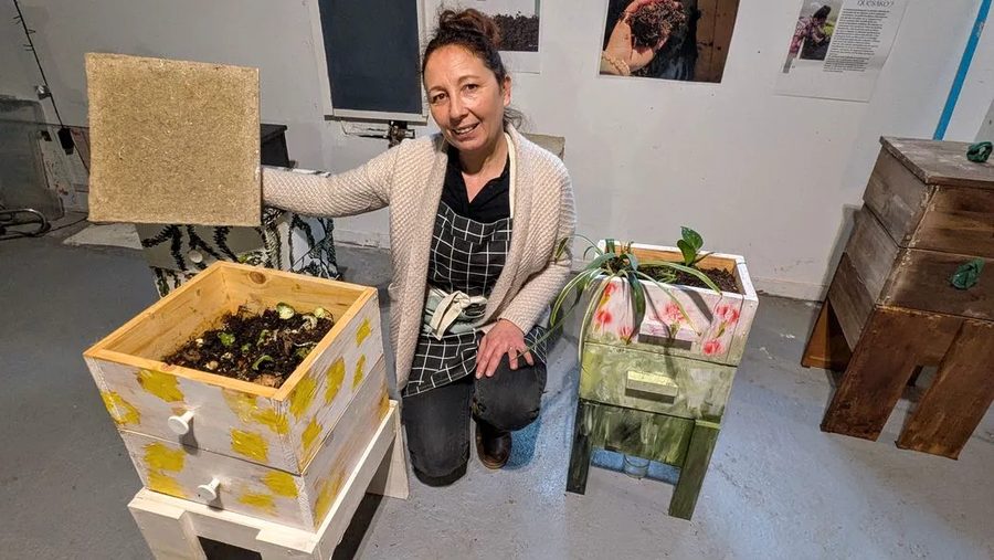 Katia, lombricultrice des Vers à Soi, à côté de deux lombricomposteurs en bois